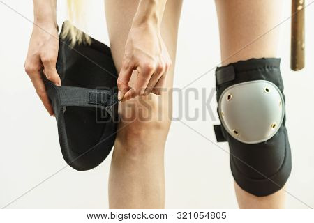 Unrecognizable Woman Wearing And Adjusting Her Safety Knee Protectors Pads. Safe Workwear During Con