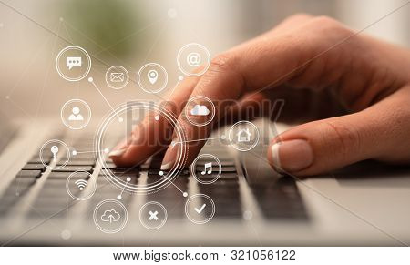 Business woman hand typing on keyboard with application icons around