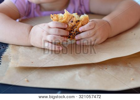 Breakfast In Restaurant On Eco Paper Bag. Kid Eat Croissant Or Bun Roll Chocolate .close Up Hand Lit
