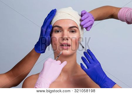 Attractive Young Woman Gets Cosmetic Injection. Doctors Hands Making An Injection In Face. Beauty Tr