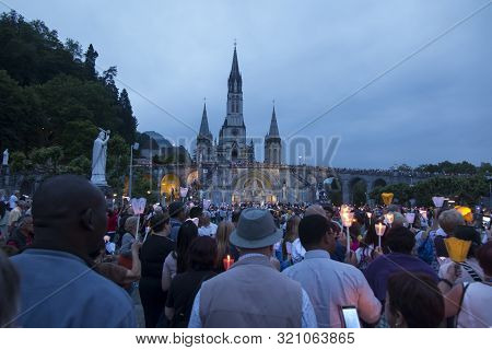 Lourdes, France, 24 June 2019: Evening Procession With Candles At The Shrine Of Lourdes In France
