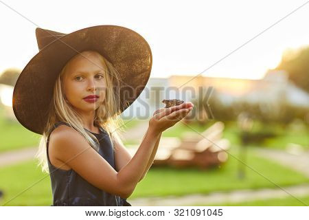 Waist Up Portrait Of Cute Little Witch Holding Frog While Posing Outdoors On Halloween, Copy Space