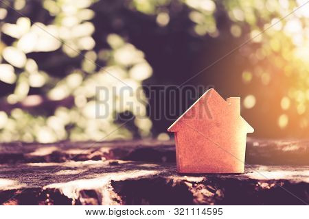 Closed Up Tiny Home Model On Floor Or Wood Board With Sunlight Green Bokeh Background. House Propert
