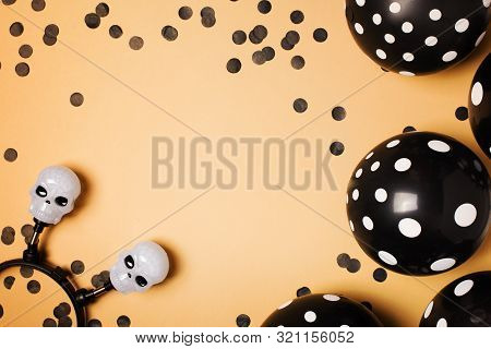 Halloween Party Flat Lay With Black Balloon, Skull And Confetti On Biege Background, Holiday And Bla