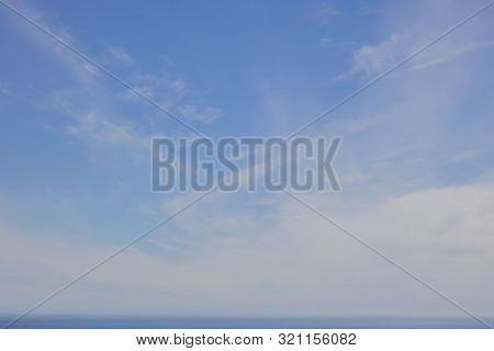 Soft Whispy Clouds On A Blue Sky Over The Ocean.