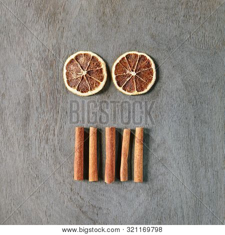 Food Art Concept with Abstract Halloween Monster made of Dried Orange Slices and Cinnamon Sticks Top Vew. Creative Layout with Skull Like Human Face made of Flat Lay Spices