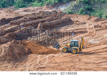Wheel Loader Excavator Machine Working In Construction Site. Wheel Loader At Sandpit During Earthmov
