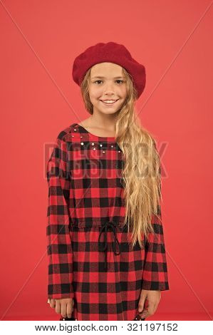 Kid Little Cute Girl With Long Hair Posing In Hat Red Background. Fashionable Beret Accessory For Fe