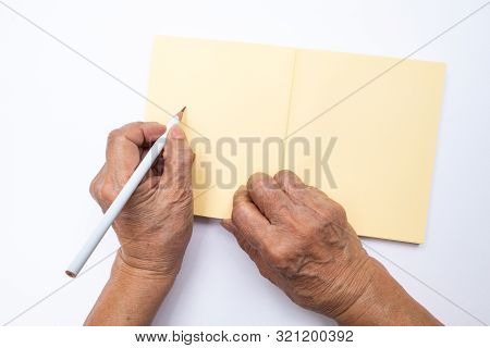 Senior Woman's Left Hand With White Pencil Writing On Notebook Isolated On White Background, , Stati