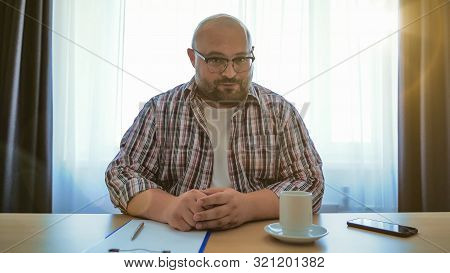 Male Online Teacher Speaks On Laptop Webcam, Fat Man In Glasses Making Videocall Or Webinar Or Job I