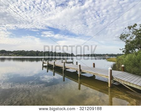 Colorful Reflections On Beautiful Florida Bayou Rustic Pier At Sunrise In Summer.