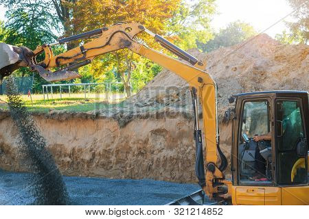 Industrial Construction Site Excavator Moving Gravel And Rocks For Foundation Under Construction Hom