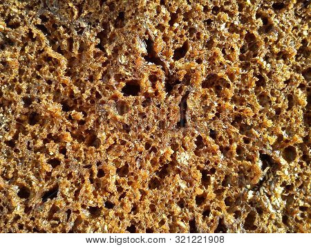 Slice Of A Loaf Of Brown Colors With Dark Air Holes
