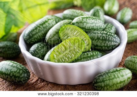 Freshly Harvested Cucamelons In Bowl On A Rustic Wood Table.