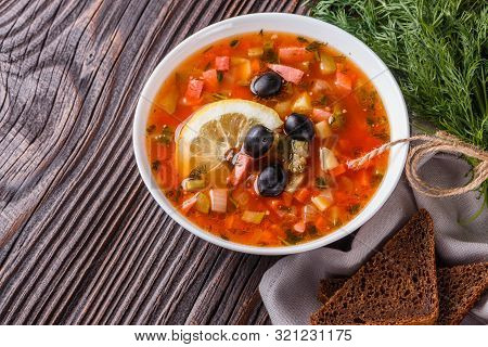 Traditional Russian Meat Soup Solyanka In Bowl On Rustic Wooden Table