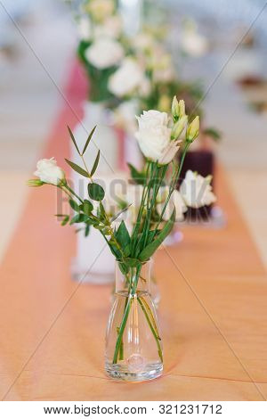 White Eustoma Flowers In Glass Transparent Vase In Wedding Or Banquet Table Decor