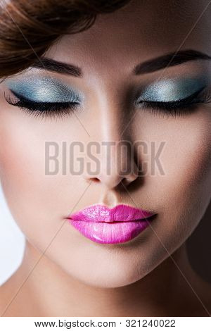 Closeup face of young adult girl with fashion bright vivid blue color eye makeup of eyelid