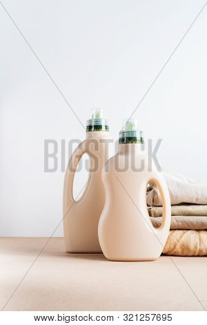 Pile Of Folded Clean Clothes With Eco Design Bottles Packaging For Mock Up Of Detergent For Laundry 