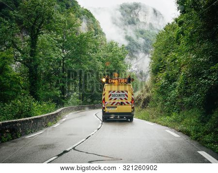 Rear View Of Yellow Roadworks Safety Van Driving Fast On Mountain Road In The Vercors Massif On A Mi