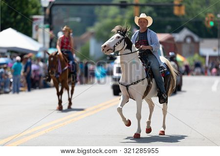 Buckhannon, West Virginia, Usa - May 18, 2019: Strawberry Festival, Caucasian Man Riding A White Hor