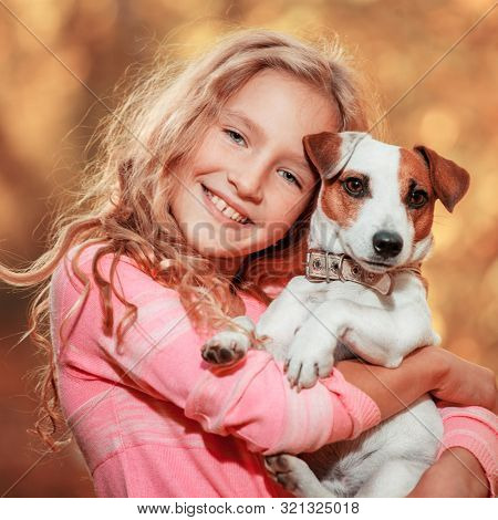Child with dog at autumn. Happy girl with pet
