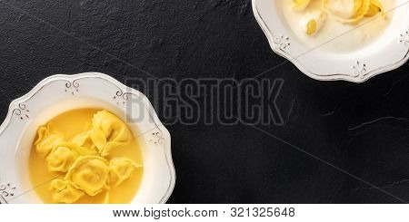 Tortellini Served With Broth And Cream Sauce, Italian Food On A Black Background With A Place For Te