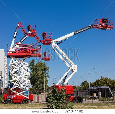 Different Self Propelled Articulated Boom Lifts And One Scissor Lift Red With White Colors On A Back