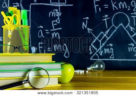 Physics Classroom At School. Physics Formulas Drawn At Chalkboard. School Supplies: Physics Books, P
