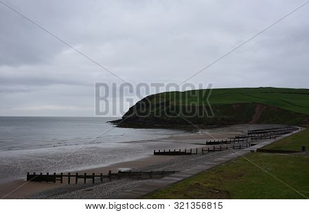 Sea Cliffs Over St Bees Beach With A Thick Cloudy Sky.