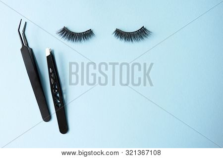 False Eye Lashes, Black Tweezers On Blue Background With Copy Space, Mockup. Beauty Concept - Tools 