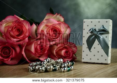 Dolce Vita Roses With Dotted White Present Box On Wood Background