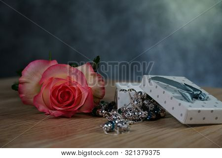Dolce Vita Roses With Dotted White Present Box On Wood Background