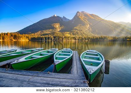 Amazing Autumn Scenery On Hintersee Lake With Boats Moored On Wooden Pier, Bavaria, Germany