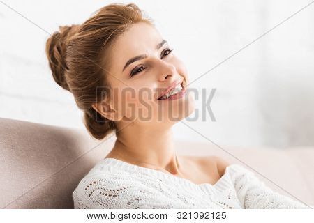 Attractive Woman In White Sweater Smiling And Looking Away