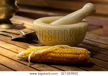 Stone Mortar Ready For Grinding Corn, Close Up. Mortar On A Wooden Table In A Rural Style With A Dry