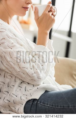 Cropped View Of Woman In White Sweater Holding Cup