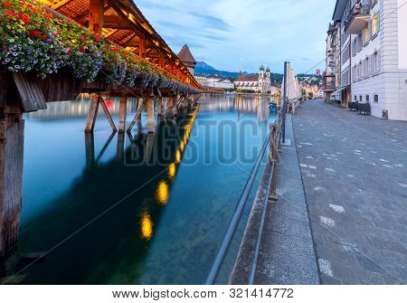 Scenic View Of The Chapel, Kapellbrucke Bridge, Wasserturm Tower In The Lantern Light At Sunrise. Lu