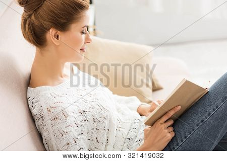 Side View Of Attractive Woman In White Sweater Reading Book