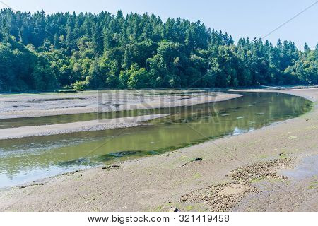 The Nisqually River Flows Past Mud Flats In The Nisqually Wetlands Near Olympia, Washington.