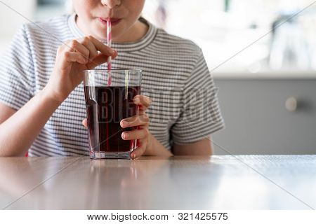 Close Up Of Girl Drinking Sugary Fizzy Soda From Glass With Straw
