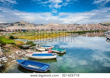 Boats and panoramic view on Puno from Titicaca lake, Peru