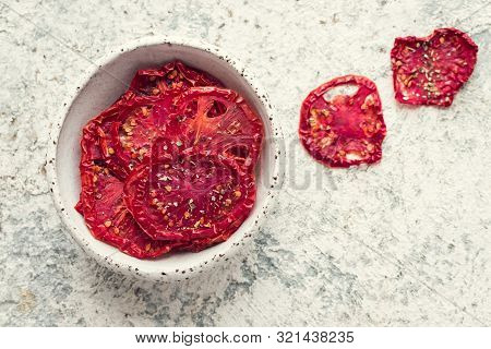 Healthy Homemade Vegetable Chips From Tomatoes With Salt, Pepper And Origano On Black Background. Or