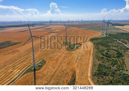 Eolian Field And Wind Turbines Farm On Countryside In A Sunny Day