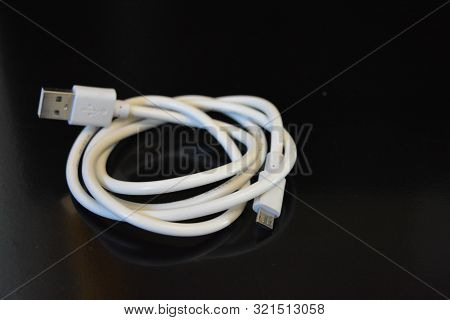 White Long Wire For Computer And Office Equipment, Usb Cable Microusb Connector On A Black Glossy Su