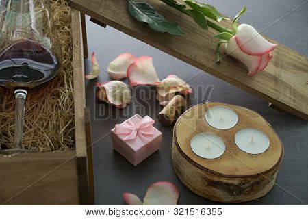 Red Wine Glass With Rose Flower On Concrete Table.