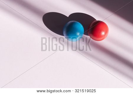 Red And Blue Ball On A Light Background With Hard Shadows. Abstract Background For Design. Copy Spac