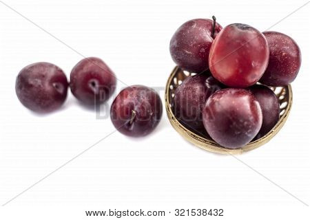 Raw Organic Red Ripe Plums In A Brown-colored Basket Isolated On White For Easy To Use For Any Purpo