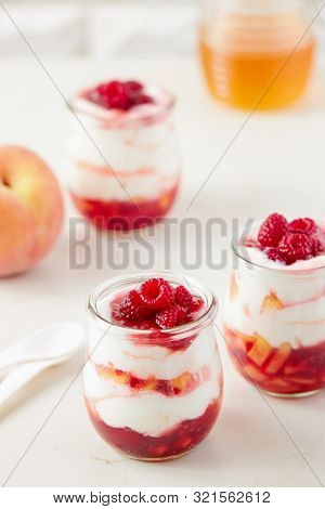 Homemade peach and raspberry dessert with yogurt cream