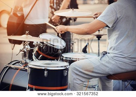 A Skilled Drummer In Gray Clothes Plays A Cool Drum Kit Wooden Drumsticks At A Concert With The Band