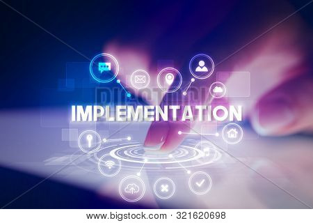 Finger touching tablet with web technology icons and IMPLEMENTATION inscription, web technology concept